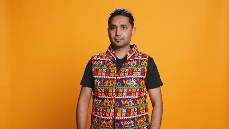 person in traditional clothing doing greeting hand gesture, studio background