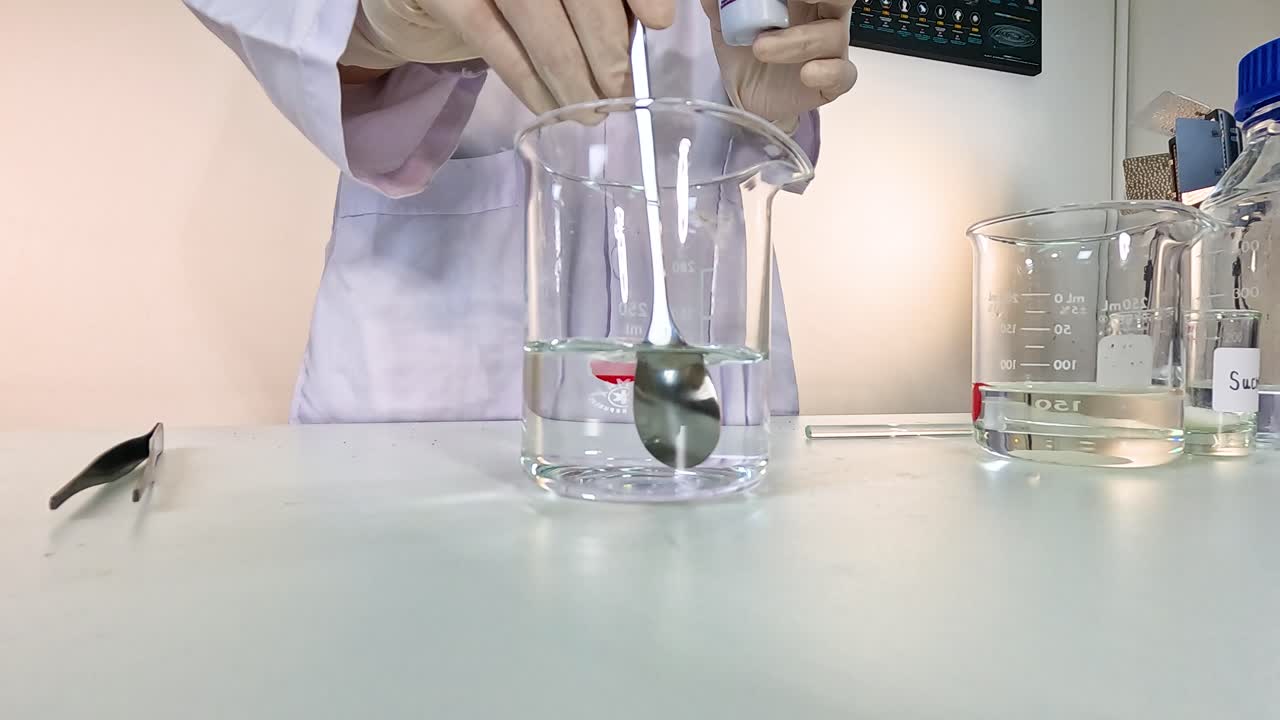 Scientist conducts a chemical experiment using potassium permanganate in a laboratory setting with clear beakers and precise movements