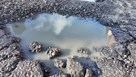 un charco en un hoyo en una carretera