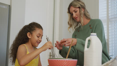 video de una hija biracial y una madre caucásica cocinando juntas