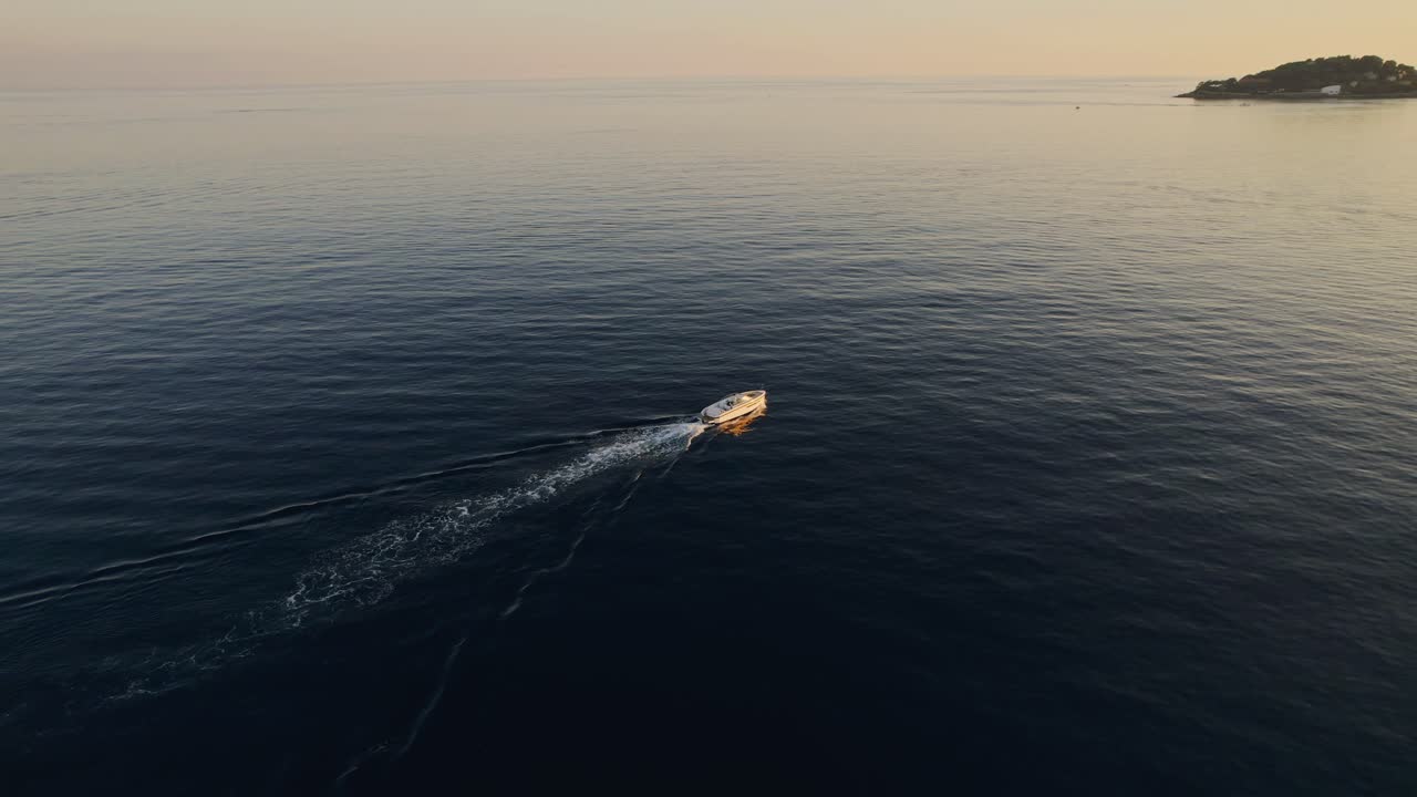 Barca al largo della costa che naviga veloce al tramonto