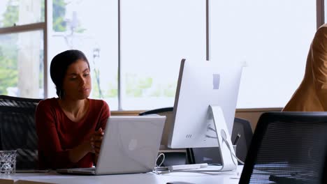 mujer ejecutiva usando una computadora portátil en el escritorio 4k
