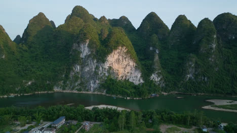 aerial view rotating toward a sunlit, mountain wall, sunset in xingping, china