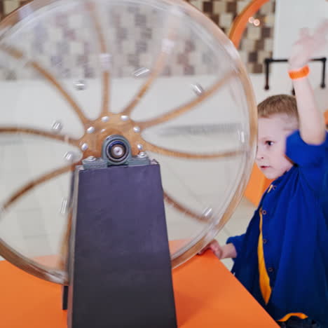 the boy examines the perpetual motion machine. scientific exhibition center