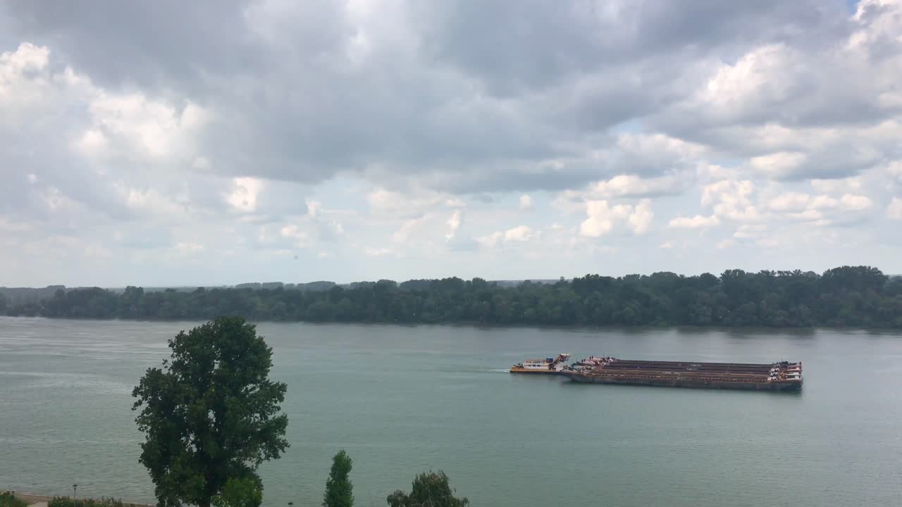 Three-piece freight tanker crossing Danube river on a rainy day in Belgrade in 4k