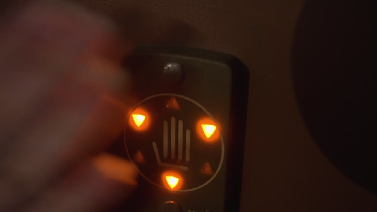 Крупный план дверной панели доступа с подсвеченной иконкой руки, пульсирующие оранжевые индикаторы по кругу, сенсорная панель готова к использованию, современная система безопасности на металлической поверхности, дизайн подчеркивает взаимодействие разблокировки