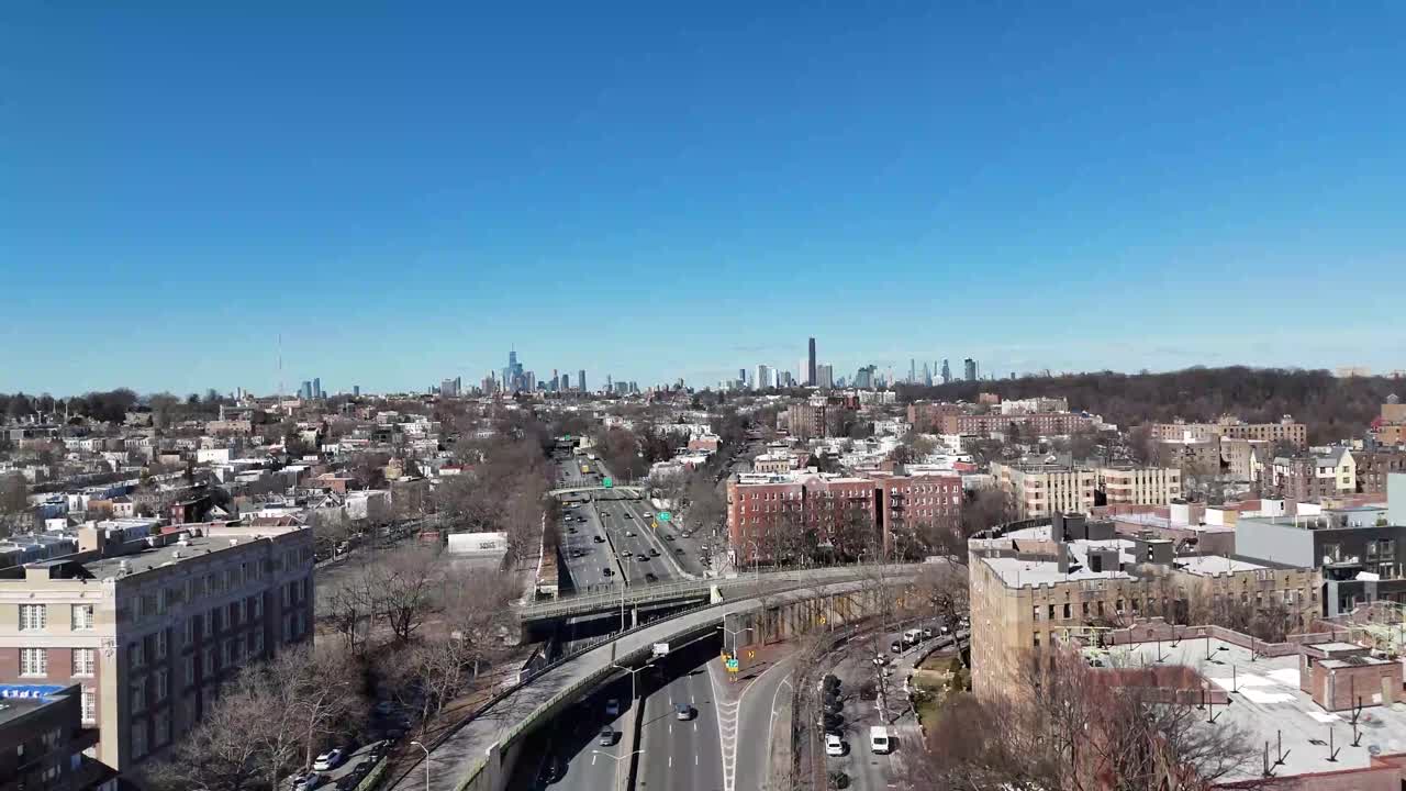 Horizontal drone ascending shot over Ocean Parkway in Brooklyn, showcasing New York’s urban streets, residential buildings, and city skyline as the camera smoothly rises.