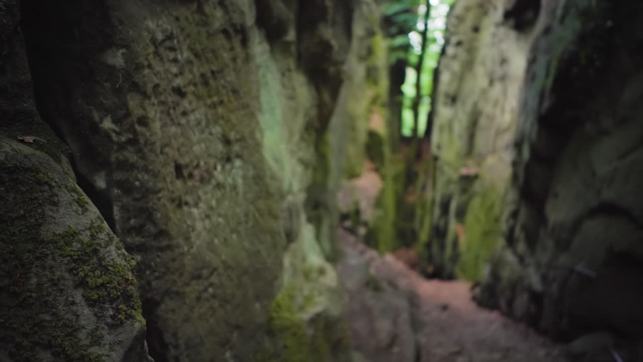 Lateral shot in Teufelsschlucht: starts focused on rugged rock walls, then shifts to the depth of the gorge, revealing a railing and trail markers.