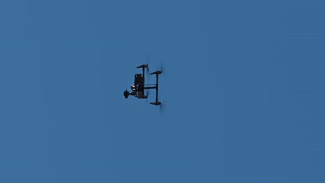 vertical: un dron comercial que vuela alto en el cielo azul durante el día