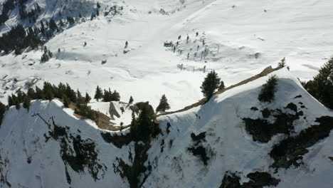 high angle jib down of trees on top of mountain overlooking snow covered valley