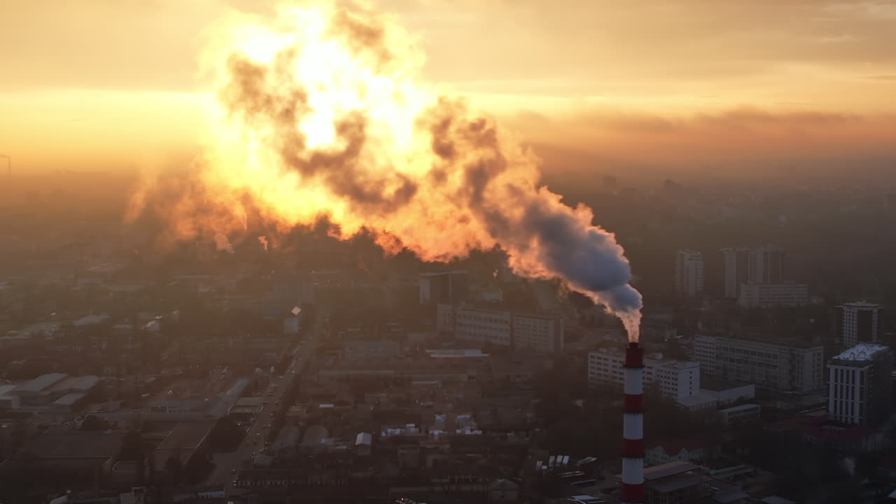 Aerial drone view of thermal power plant in Chisinau at sunrise, Moldova. View of pipe with felling steam, cityscape