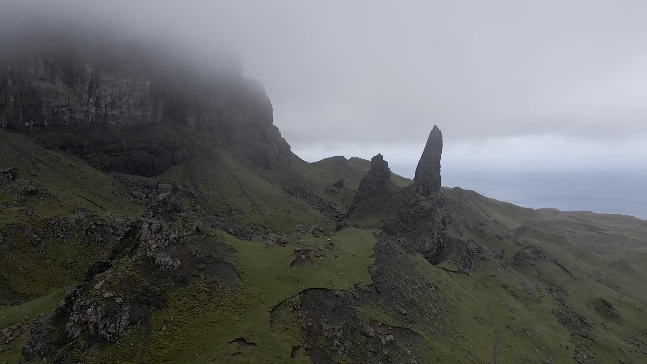 imágenes aéreas de drones de 4k que se acercan desde la niebla y la niebla para ver despejadas al anciano de storr isla de skye escocia reino unido rocas montañas