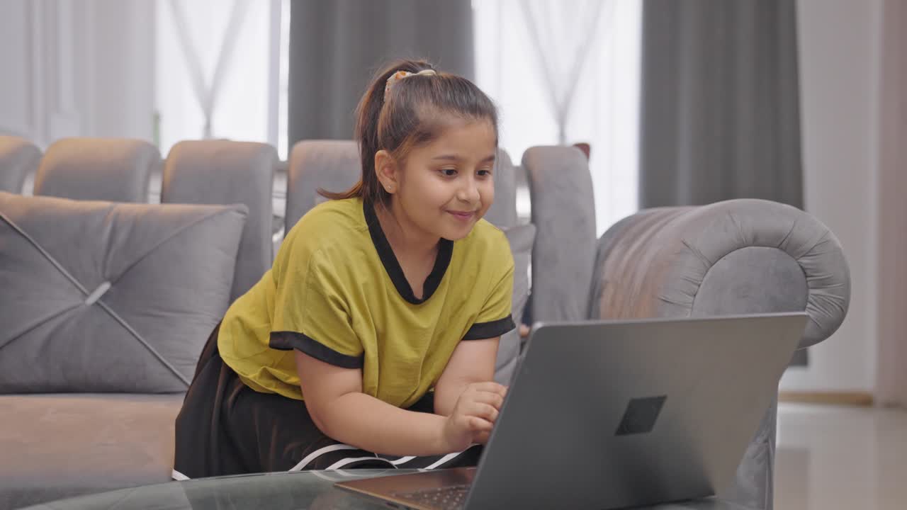 chica india feliz usando una computadora portátil