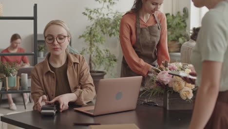 female florists selling flowers to customer