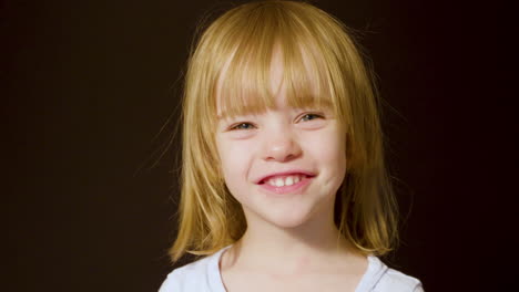 portrait of a beautiful little girl turning toward the camera and smiling