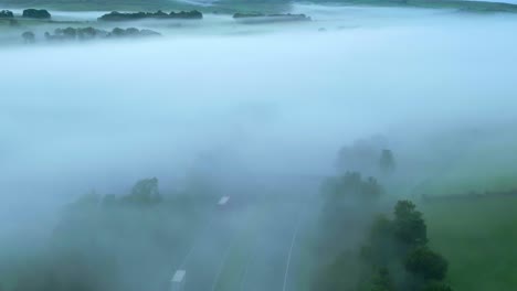 Rising-above-misty-and-foggy-M6-motorway-revealing-mist-shrouded-fields-and-hills-at-sunrise
