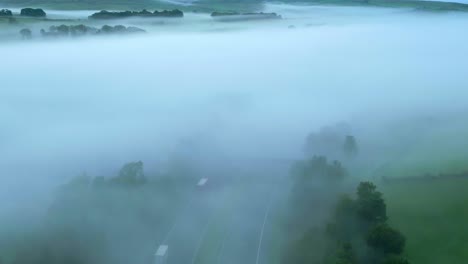 über der nebligen und nebligen m6-autobahn, die bei sonnenaufgang neblige felder und hügel offenbart