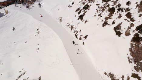 fast skier overtaking people skiing down snow covered mountain