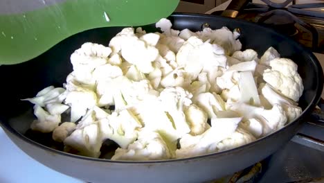 agregar coliflor cruda a una sartén, cerrar