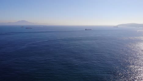 aerial pan left view of the strait of gibraltar with ships in background