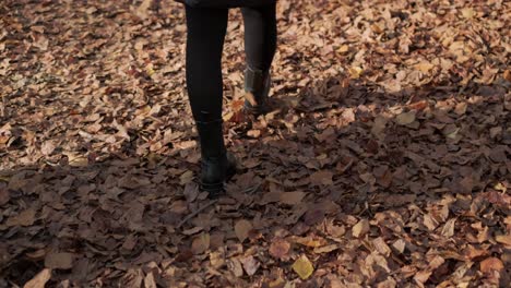 Caminar-Sobre-Hojas-De-Otoño-Un-Primer-Plano-De-Las-Botas-De-Mujer-Mientras-Camina-En-El-Bosque