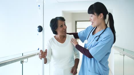 Young-female-doctor-greeting-patient-in-hospital-corridor-4k