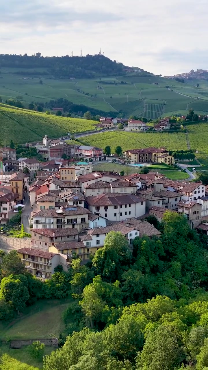 Luftoptagelser fra drone panorerer hen over den historiske landsby Barolo og frodige italienske vinmarker