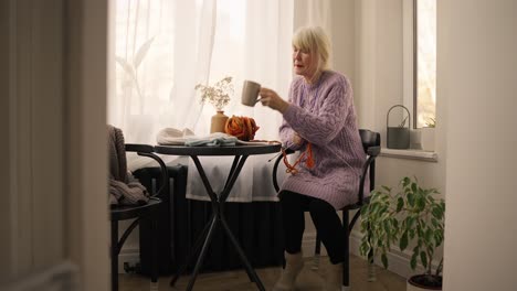 elderly woman knitting at home
