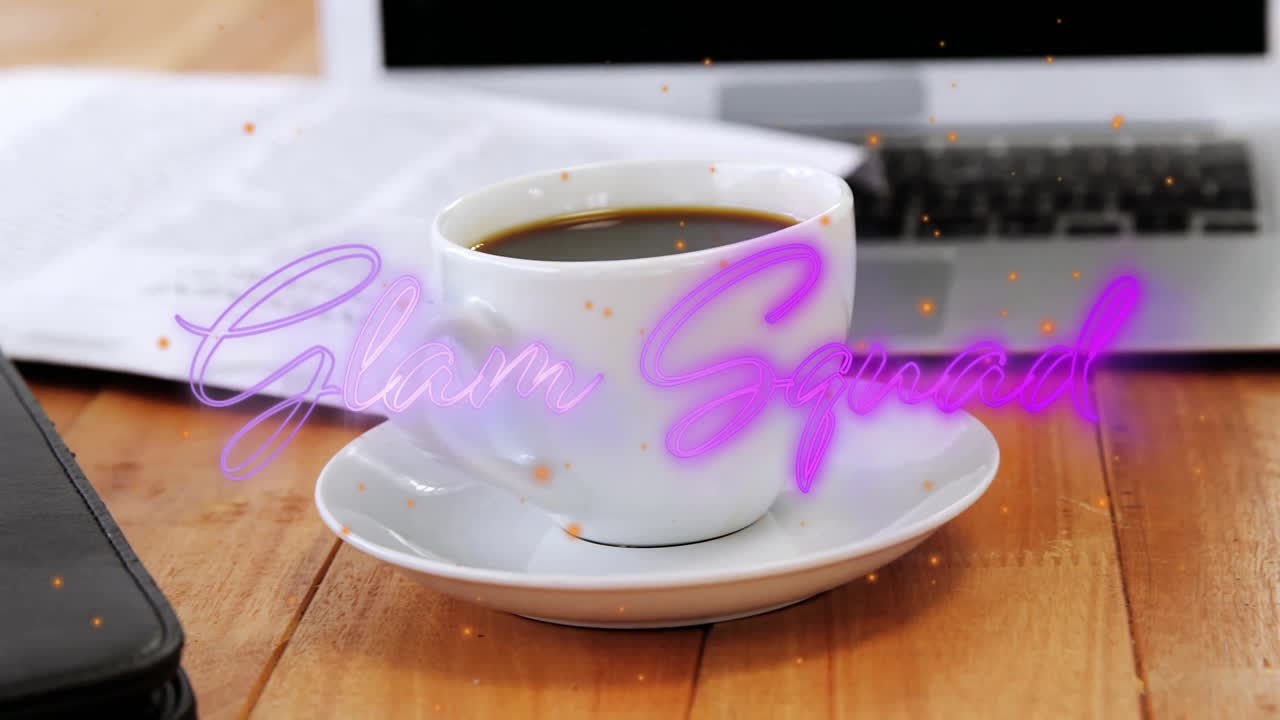 White ceramic coffee cup sitting on office desk with floating neon Glam Squad flat design sparkles