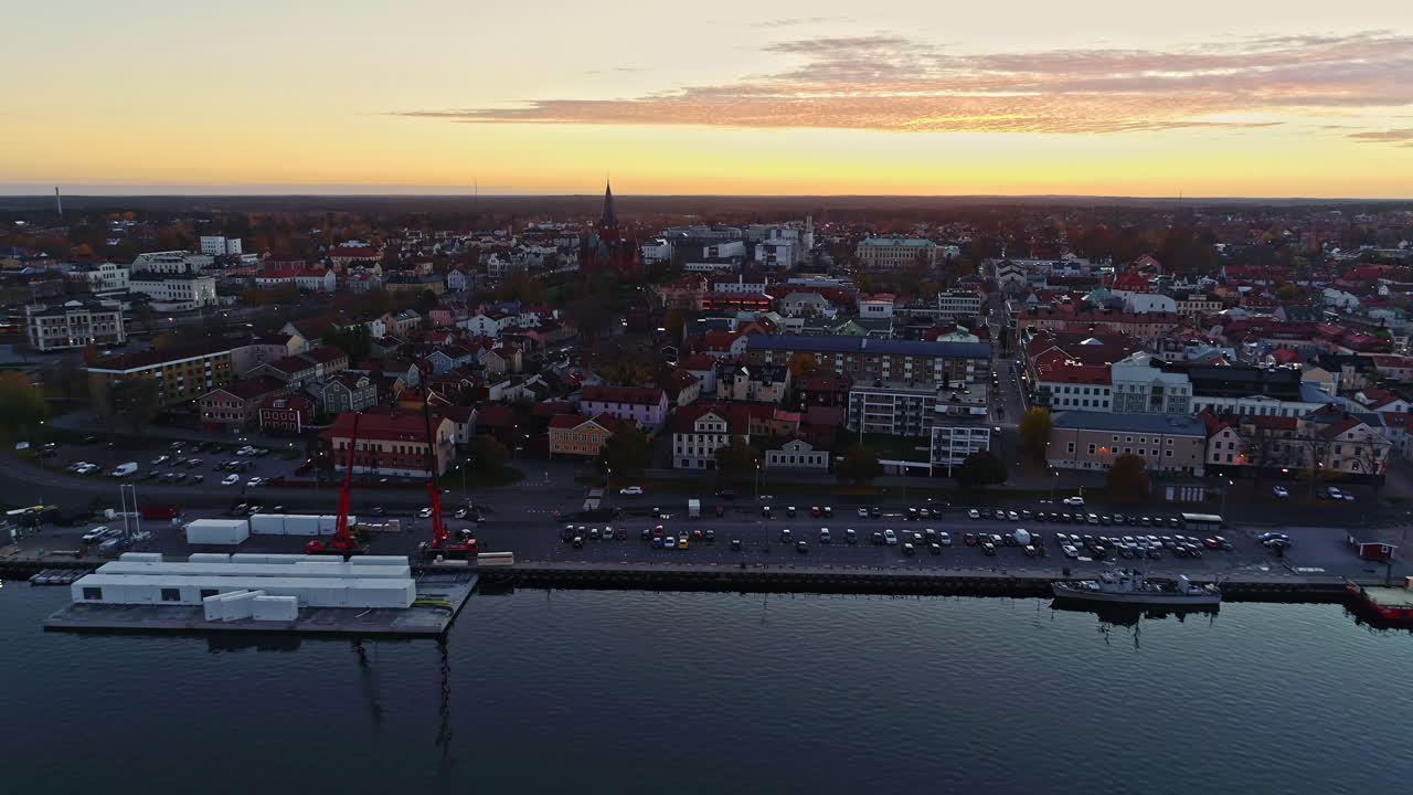 Aerial backwards shot of Slottsholmen City with Church, Old Buildings and Waterfront at sunset