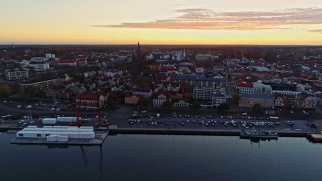 toma aérea hacia atrás de la ciudad de slottsholmen con iglesia, edificios antiguos y frente al mar al atardecer