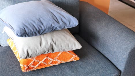 close up of three pillows on a blue couch