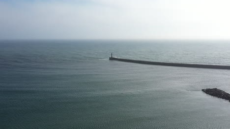 aerial crane shot of ocean breakwater on portugal coast, daytime