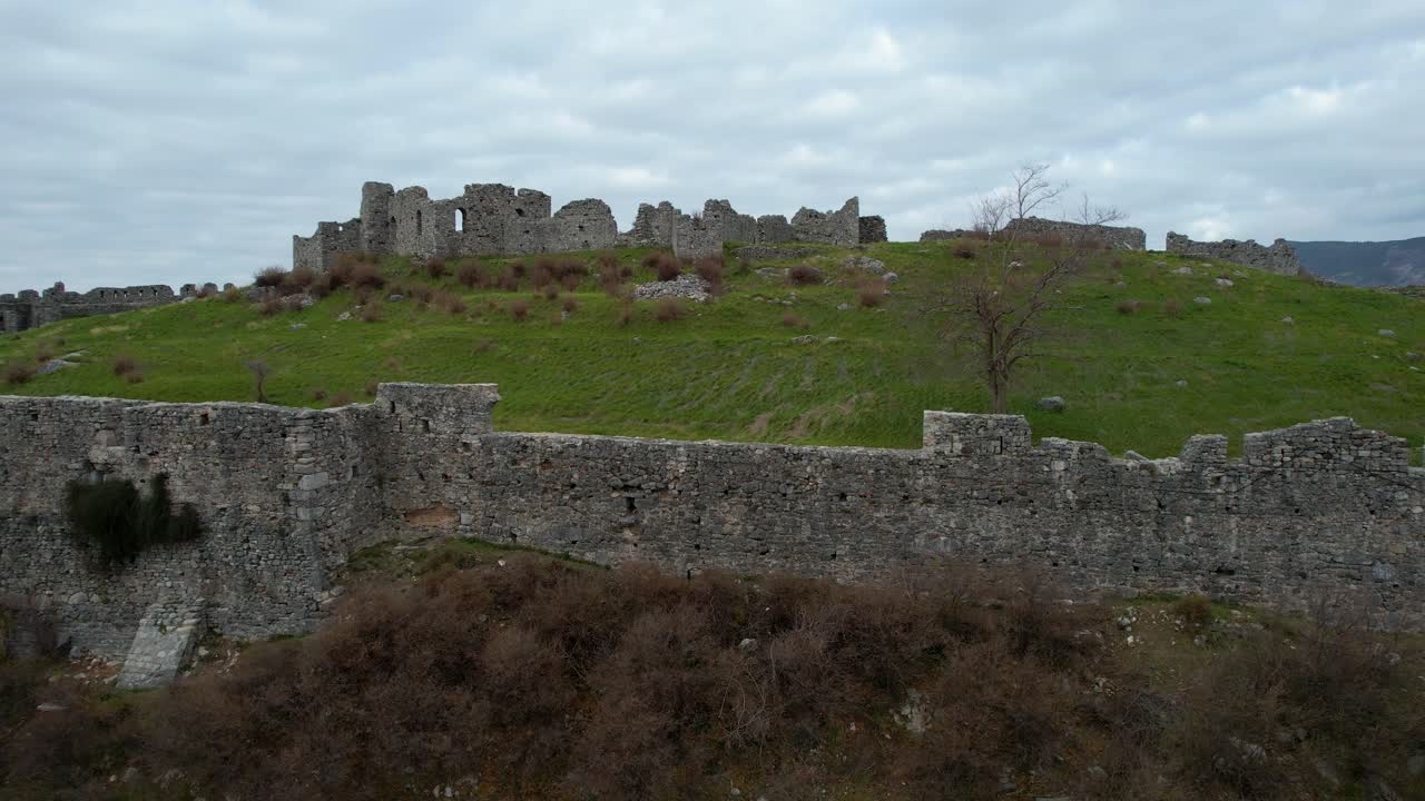 drama épico mudo: el castillo de lezha se encuentra majestuoso en la colina con altas paredes de piedra, haciendo eco de antiguas batallas en un día oscuro