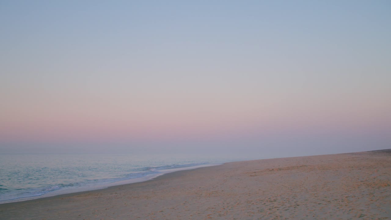 해변의 파도와 함께 수평선에 있는 파스텔 하늘
