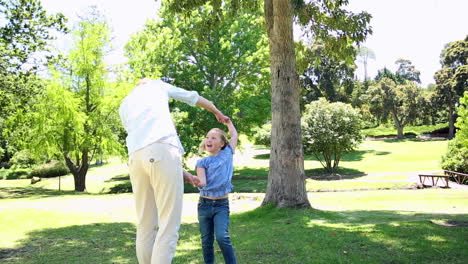 Glückliche-Mutter-Hält-Händchen-Mit-Ihrem-Kleinen-Mädchen-Im-Park