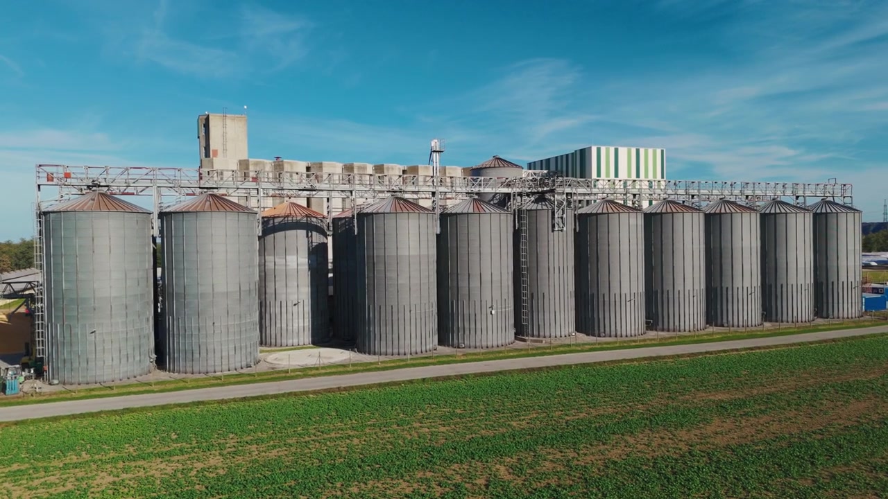 Luftaufnahme, die große Getreidesilos und Lagereinrichtungen in einem ländlichen Gebiet zeigt.