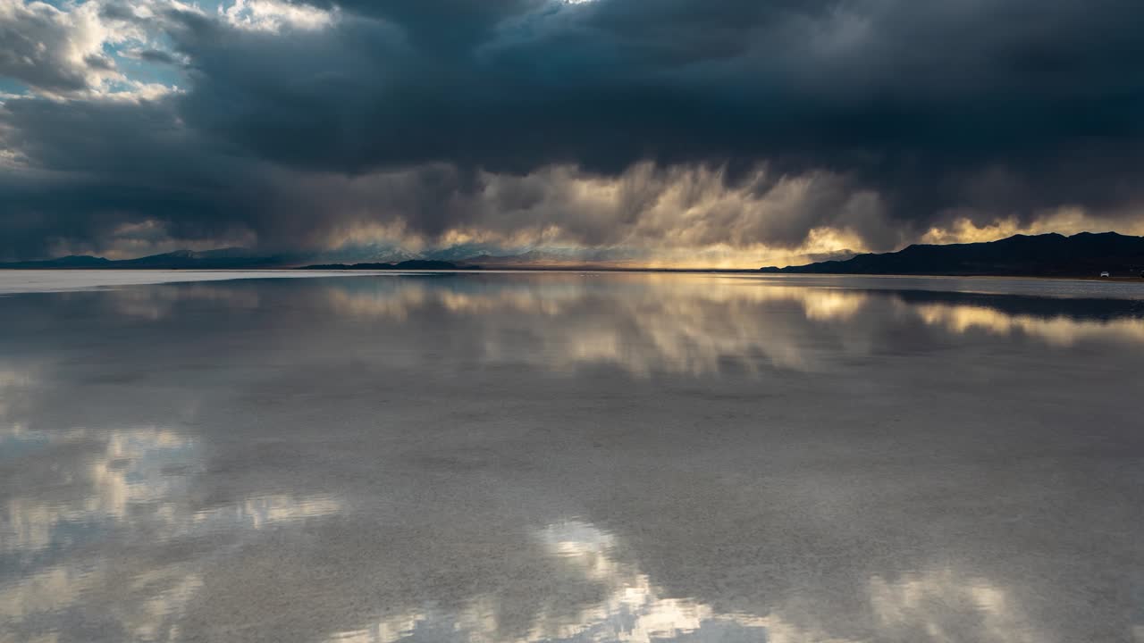 Timelapse, Dark Rainy Clouds and Sunset Sky Reflection on Calm Water in Bonneville Salt Flats, Utah USA