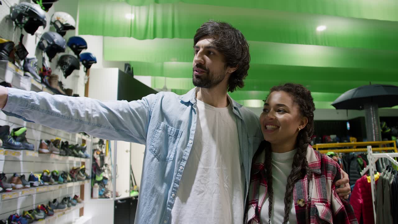 una joven pareja mirando el calzado en la tienda deportiva