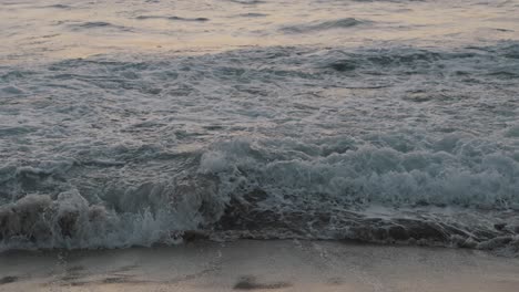 Enormes-Olas-Del-Salvaje-Océano-Pacífico-Llegan-A-La-Playa-De-Arena-Mientras-Varias-Personas-Nadan-En-El-Mar-Justo-Después-Del-Atardecer-En-México