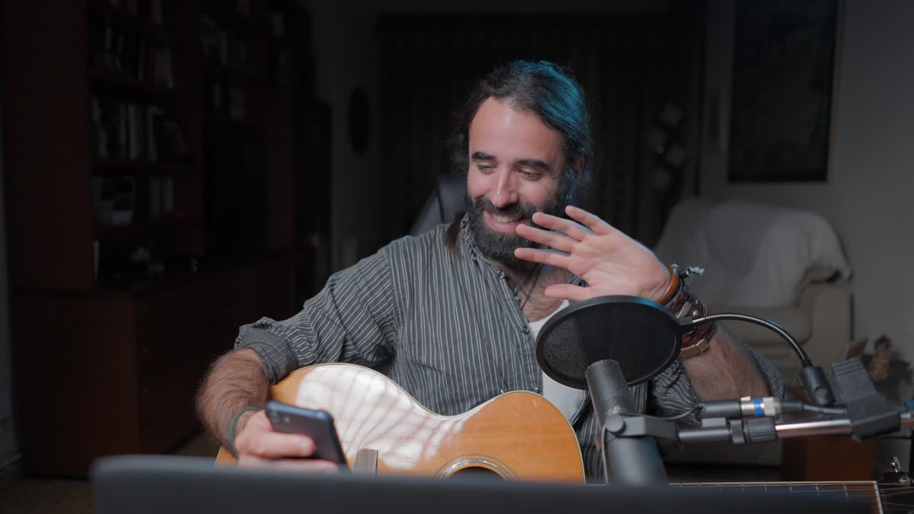 Man Playing Guitar and Streaming Music Online