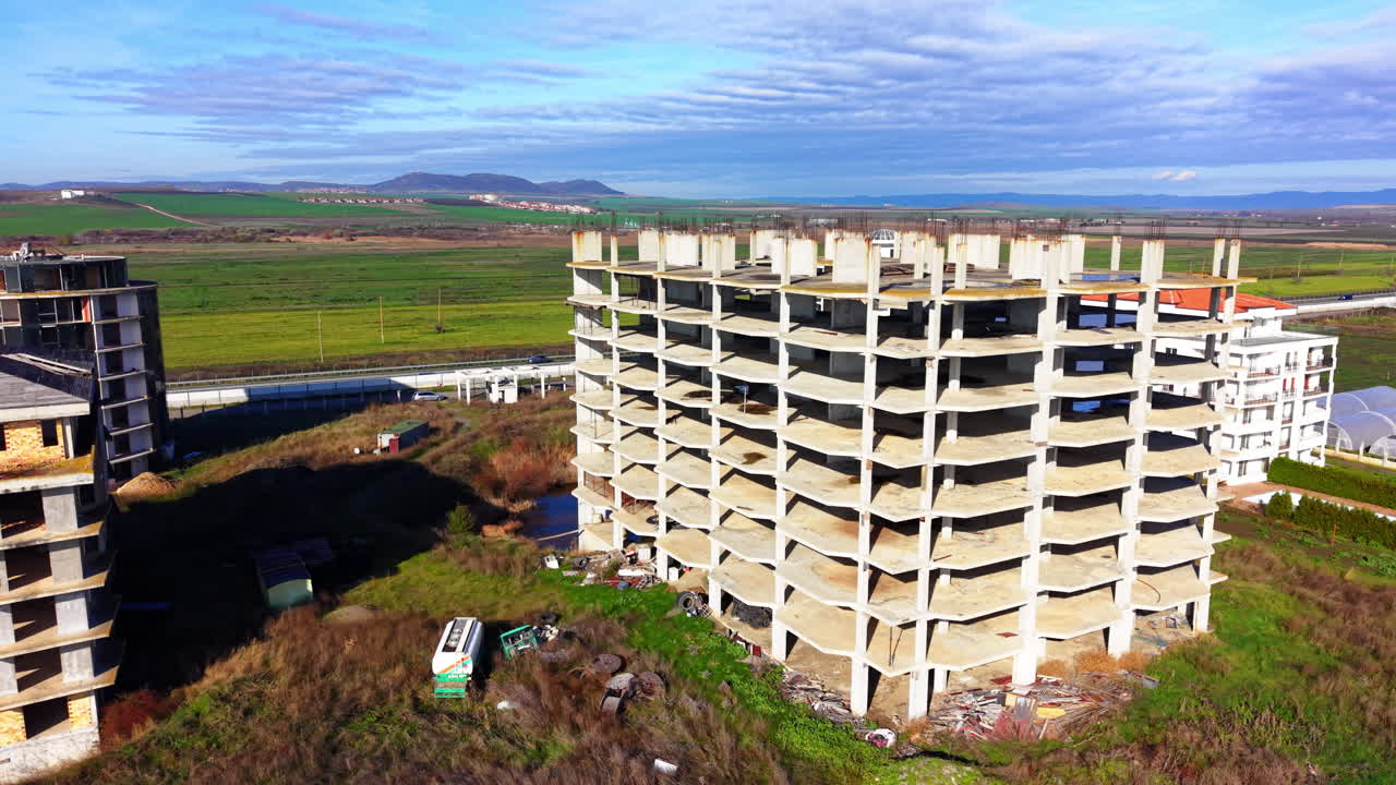 Vista aérea general de varios edificios de apartamentos sin terminar y proyectos de construcción situados en un campo verde cerca de una autopista. Bulgaria