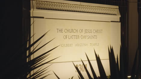 sign of the church of jesus christ of latter-day saints lds mormon temple church building at night illuminated by warm light in gilbert, arizona