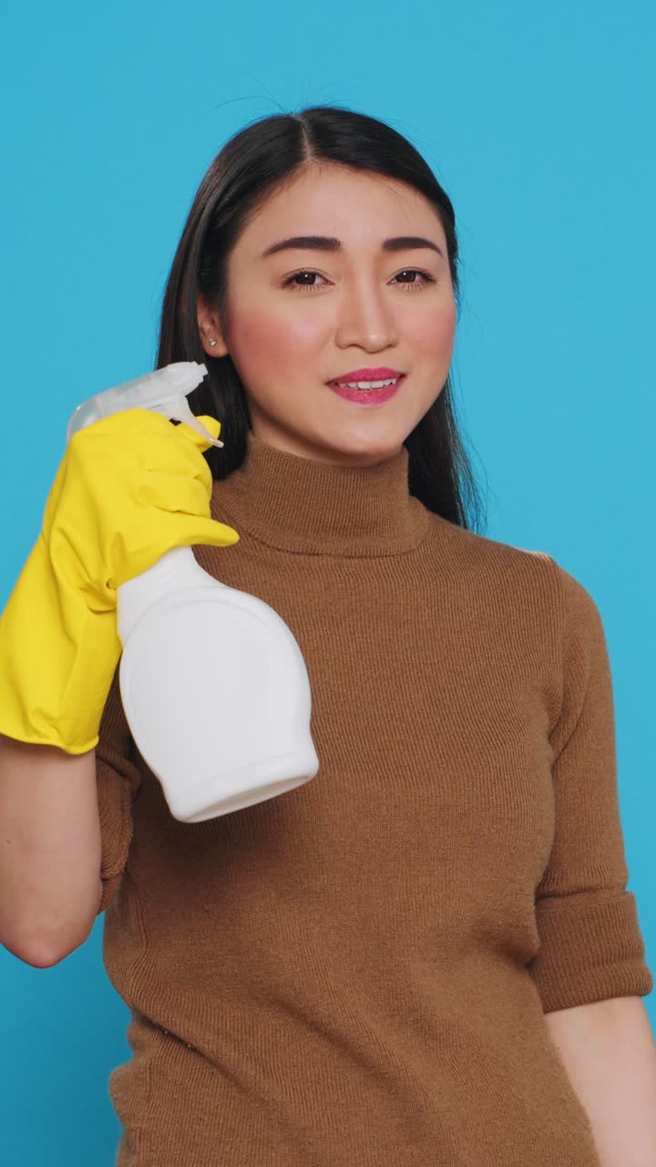Vertical video: Cleaning woman pointing and showing cleaning product or isolated text