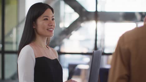 Asian-businesswoman-discussing-together-with-colleagues-and-using-laptop