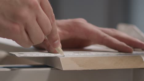 close up shot of hand using pencil to mark cutting lines on skirting board