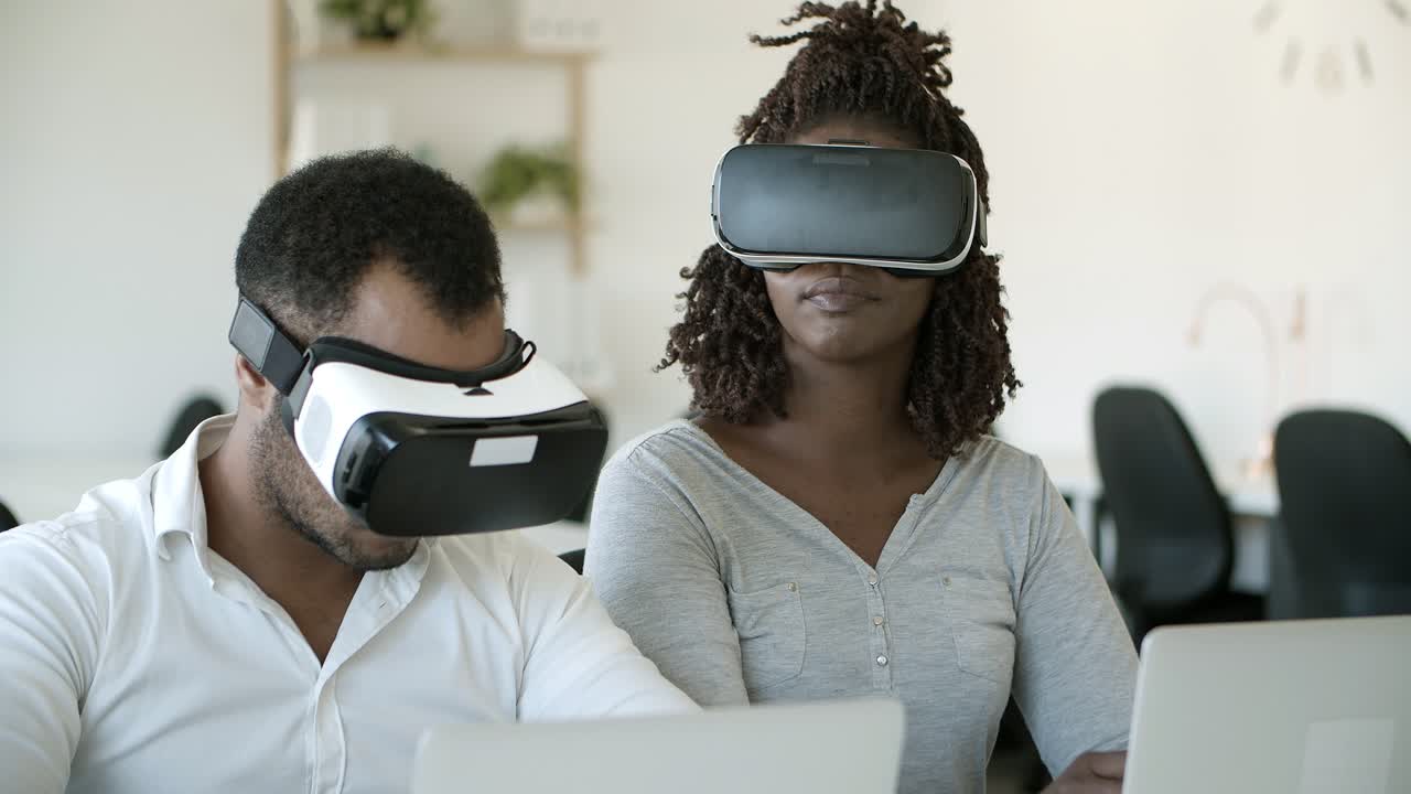 Excited users wearing VR headsets while sitting in office