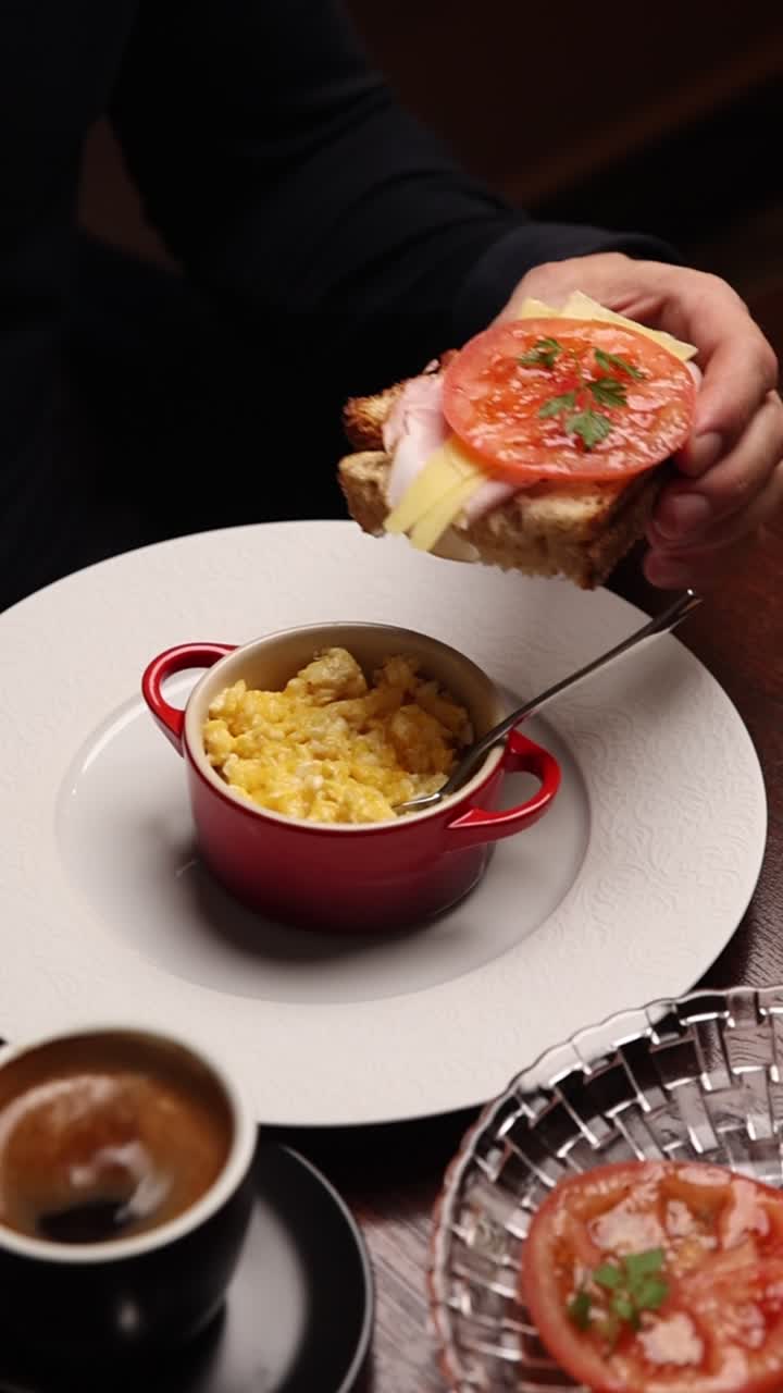 Colazione deliziosa con uova strapazzate, sandwich e caffè