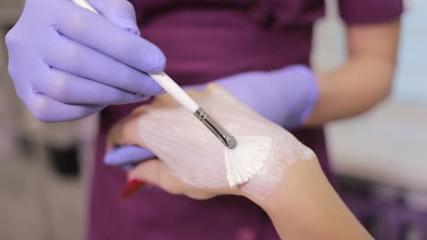 applying a cream mask to a hand