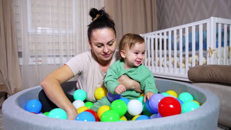mother and baby playing in a ball pit